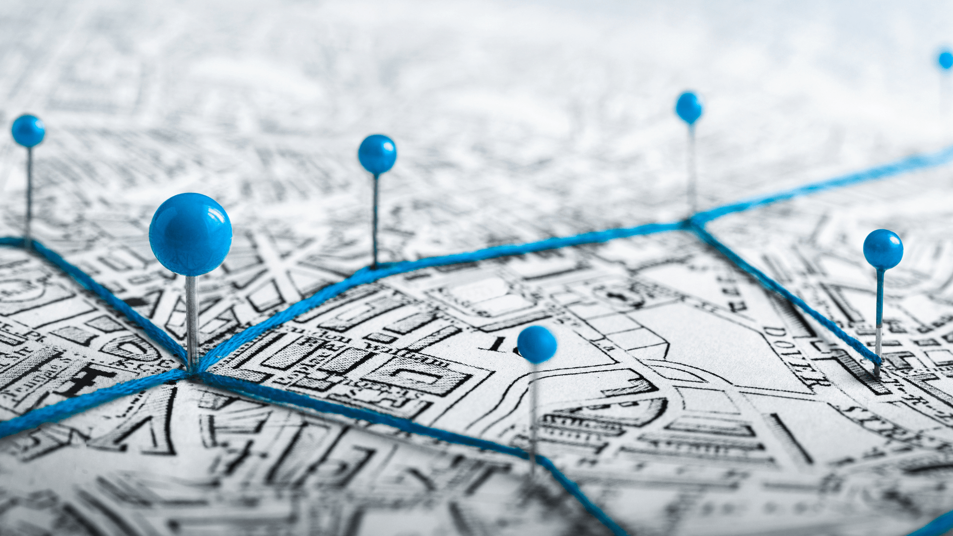 Paper map with pins and string representing territories
