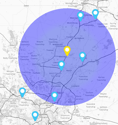 Screenshot of a purple radius circle on a grayscale map. Four blue pins and one yellow pin lie within the circle. Two blue pins lie outside of the circle.